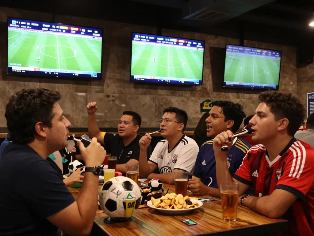 Exciting KQBD updates in a lively sports bar atmosphere with fans cheering